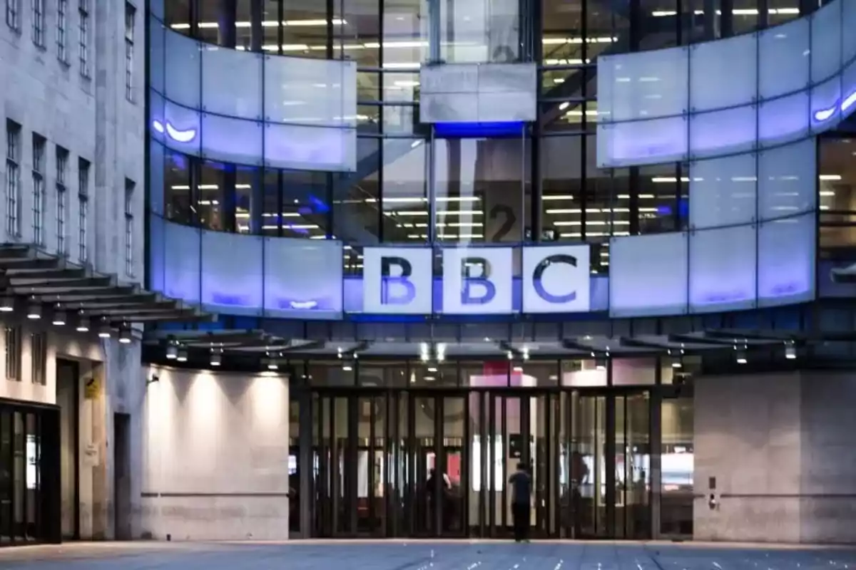 Fachada principal del edificio de la BBC con luces azules y puertas de vidrio