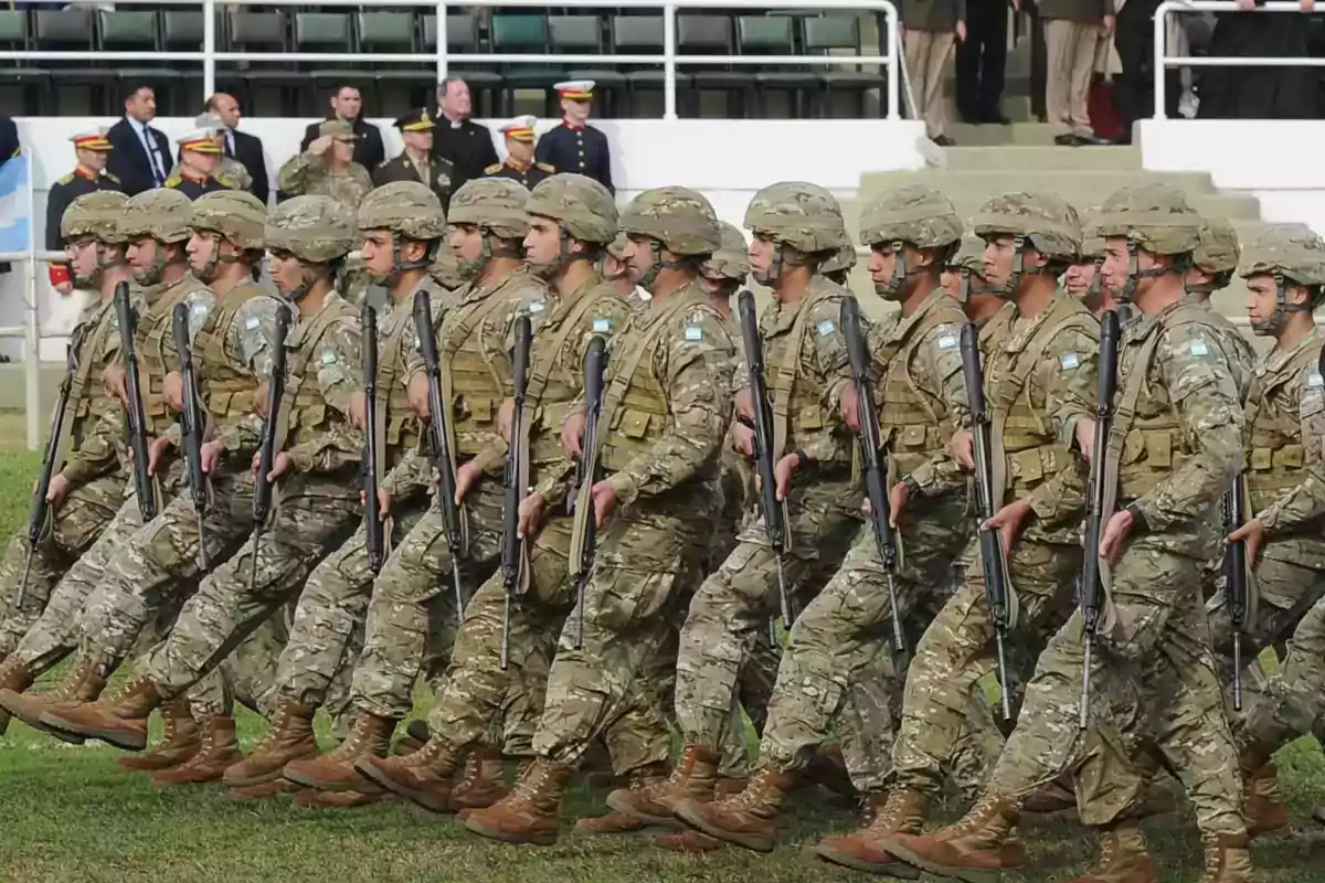 Soldiers marching in formation wearing camouflage uniforms and rifles in a military parade Soldiers marching in formation wearing camouflage uniforms and rifles in a military parade