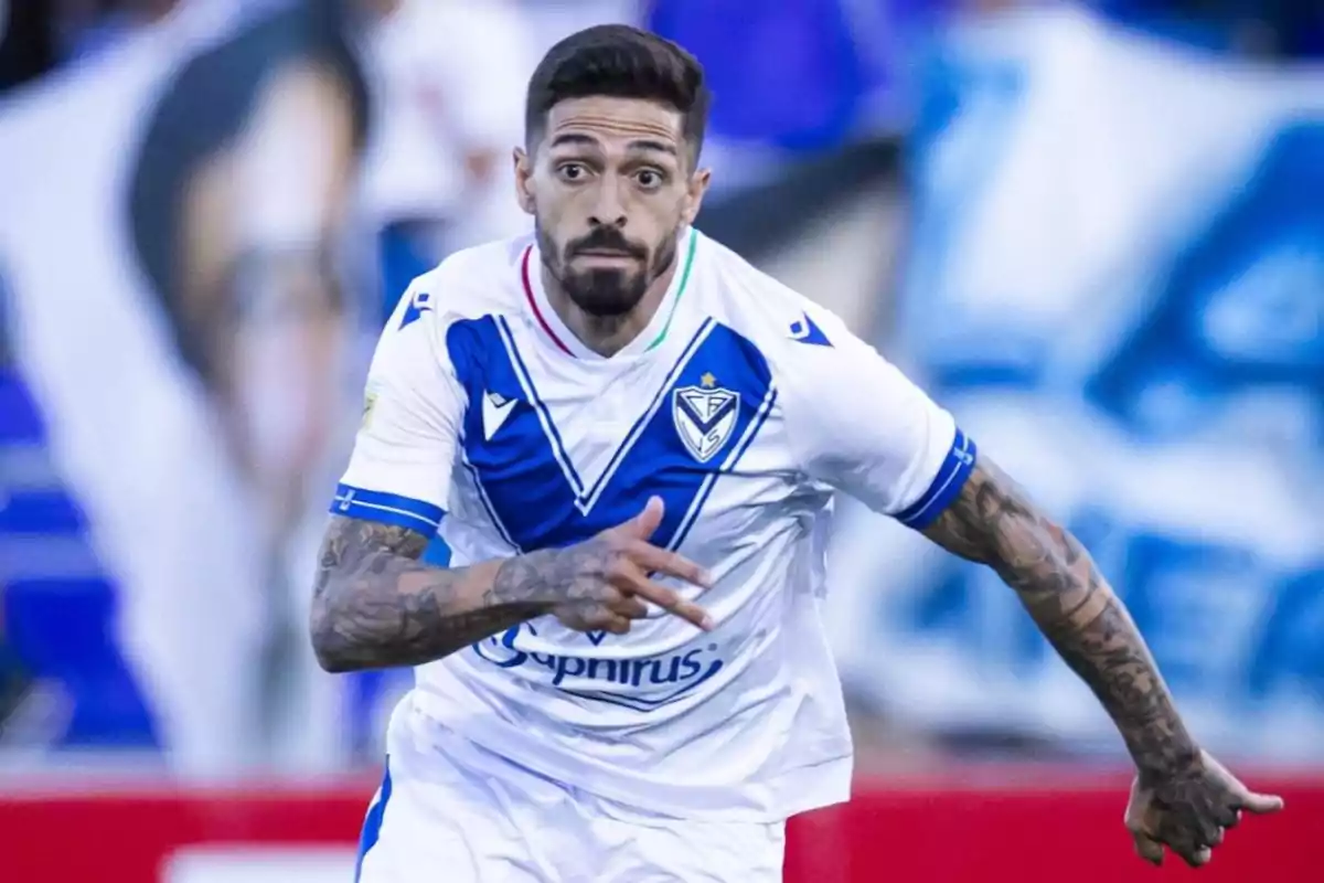 Soccer player in Vélez Sarsfield’s white and blue uniform running on the field during a match
