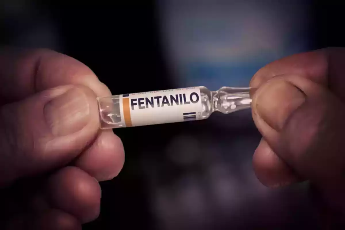 Hands holding a glass vial labeled fentanyl