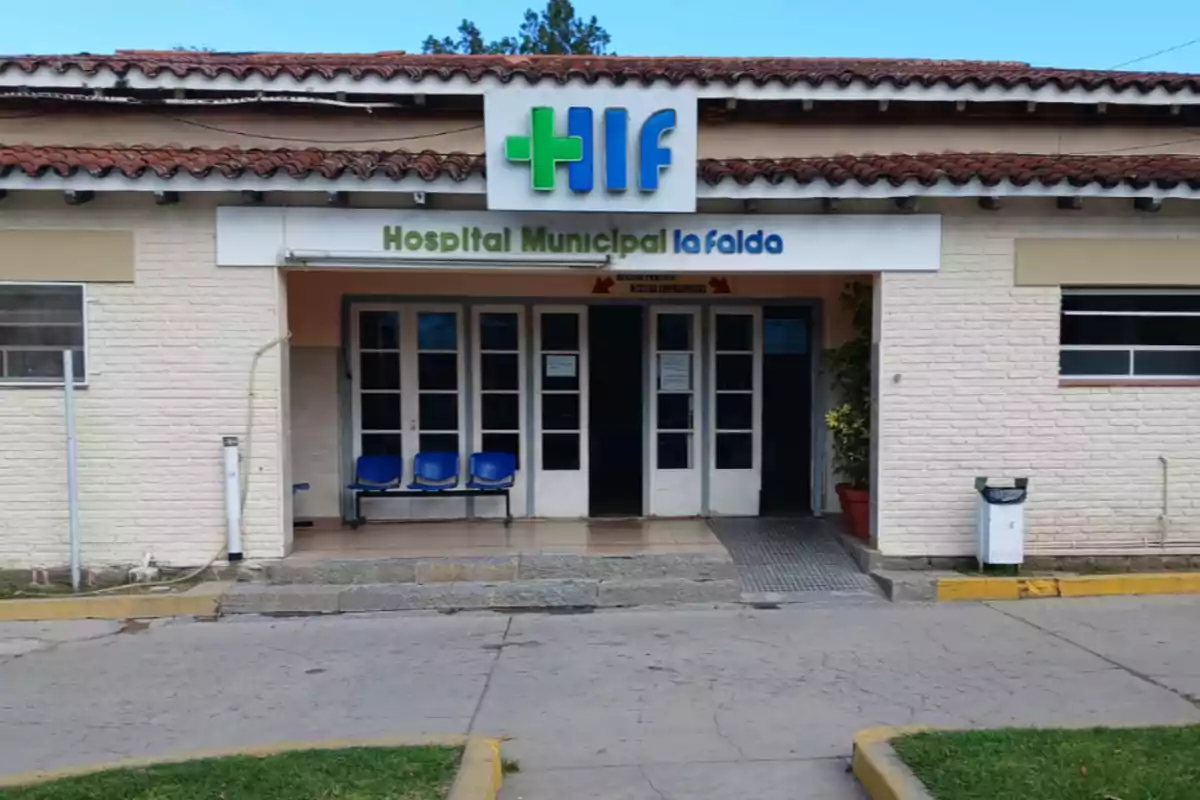 Fachada del Hospital Municipal La Falda con sillas azules en la entrada y un cartel identificatorio sobre la puerta principal