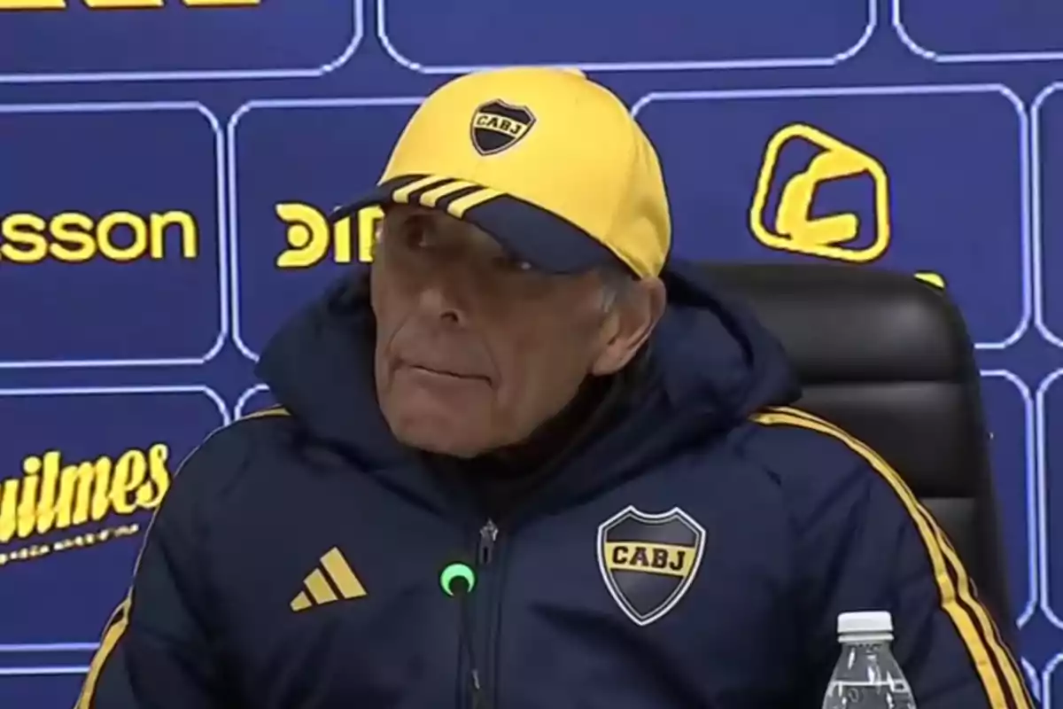 Boca Juniors coach wearing a club cap and jacket at a press conference