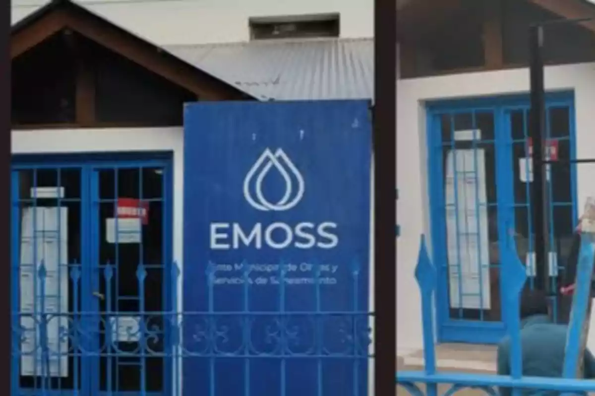 Fachada de un edificio con puertas y ventanas azules y un cartel grande que dice EMOSS junto a un logotipo de gotas de agua Fachada de un edificio con puertas y ventanas azules y un cartel grande que dice EMOSS junto a un logotipo de gotas de agua
