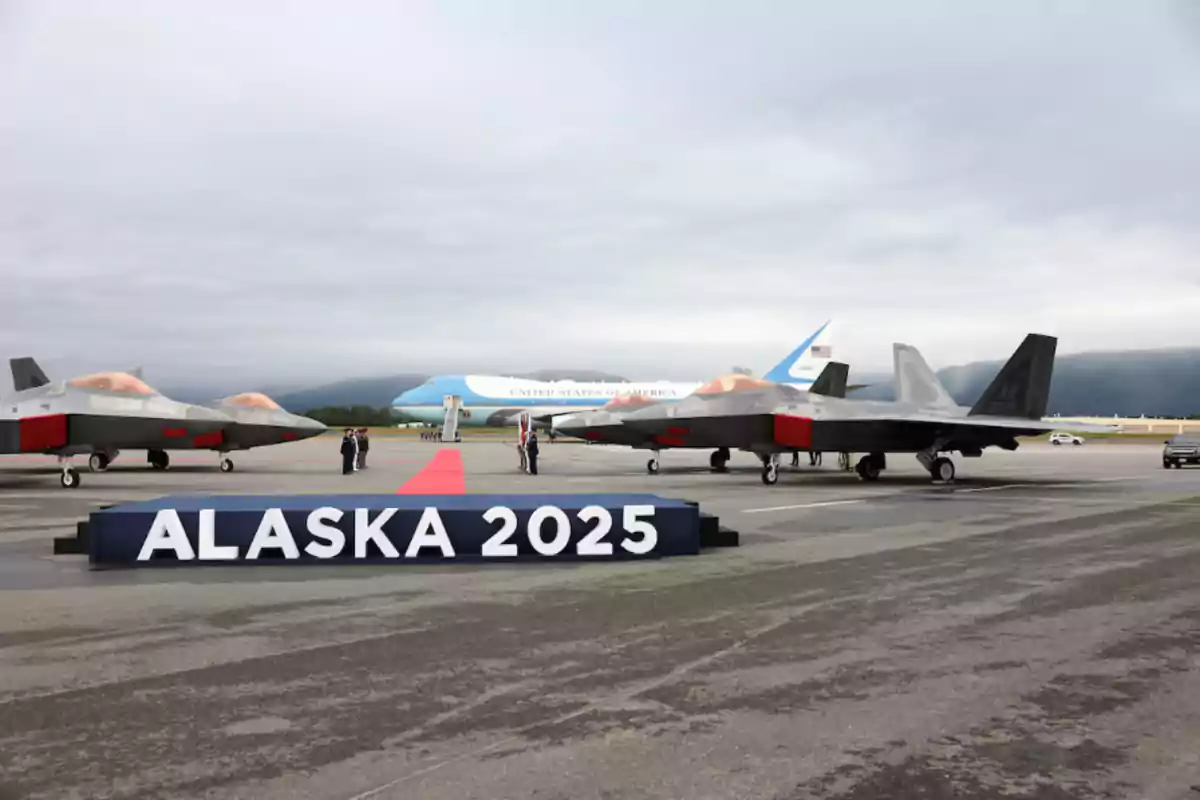 Military planes and a presidential plane on a runway with a sign that says ALASKA 2025 and a red carpet in the center Military planes and a presidential plane on a runway with a sign that says ALASKA 2025 and a red carpet in the center