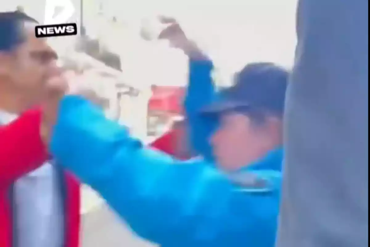 Person in a blue uniform and cap raising their arms in front of another person in a red jacket in a tense situation on the street Person in a blue uniform and cap raising their arms in front of another person in a red jacket in a tense situation on the street