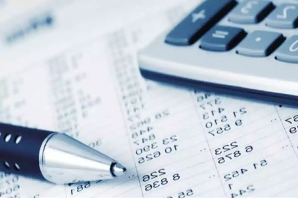 Pen and calculator on a sheet with numbers and financial calculations Pen and calculator on a sheet with numbers and financial calculations