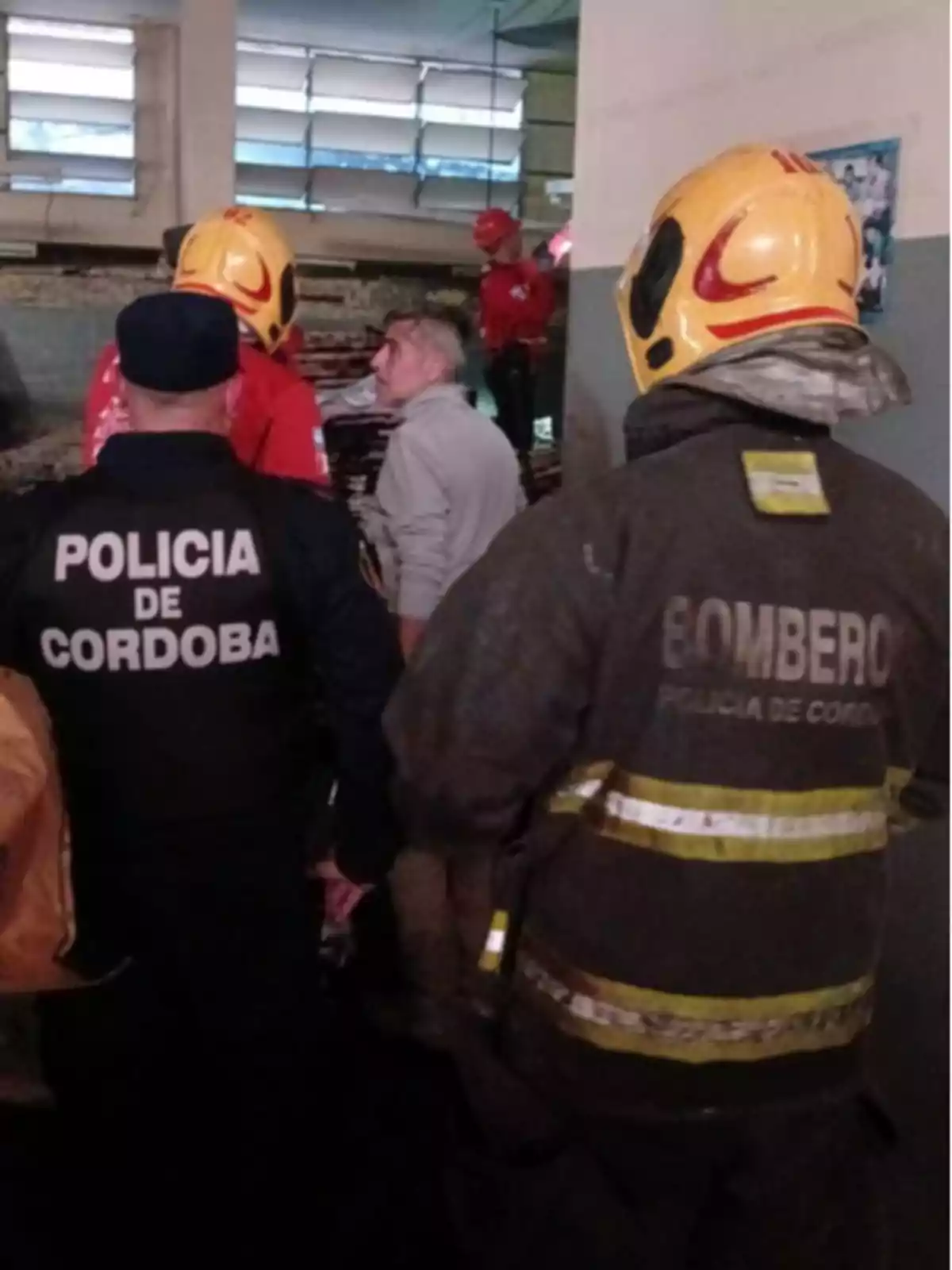 Several members of the police and firefighters from Córdoba are inside a building carrying out a rescue or emergency operation; some are wearing helmets and special uniforms. Several members of the police and firefighters from Córdoba are inside a building carrying out a rescue or emergency operation; some are wearing helmets and special uniforms.