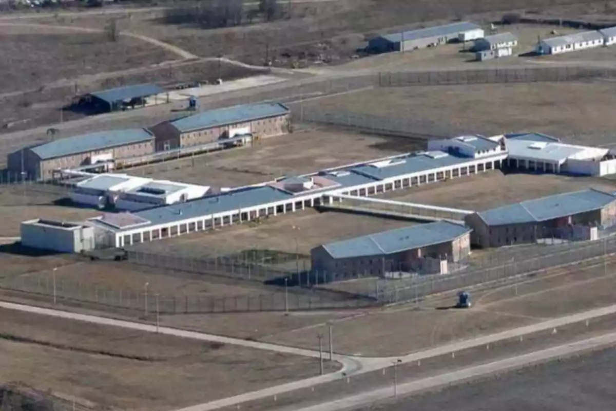 Aerial view of a prison complex surrounded by fences and buildings spread out over a large area Aerial view of a prison complex surrounded by fences and buildings spread out over a large area