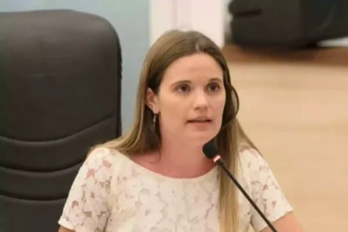 Mujer joven hablando frente a un micrófono en una sala de reuniones Mujer joven hablando frente a un micrófono en una sala de reuniones