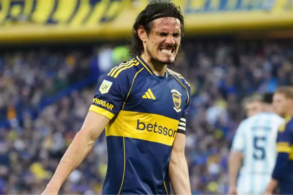 Futbolista con gesto de dolor usando el uniforme azul y amarillo de Boca Juniors en un estadio lleno