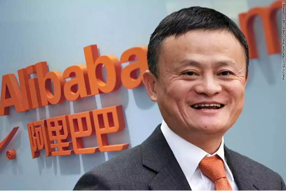 Hombre sonriente con traje y corbata naranja frente al logo de Alibaba en letras naranjas