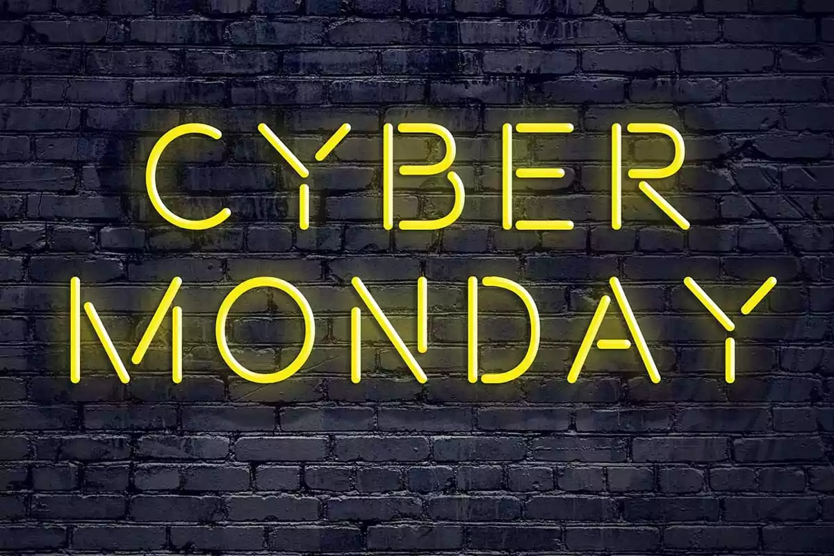 Letrero de neón amarillo con las palabras Cyber Monday sobre una pared de ladrillos oscuros Letrero de neón amarillo con las palabras Cyber Monday sobre una pared de ladrillos oscuros