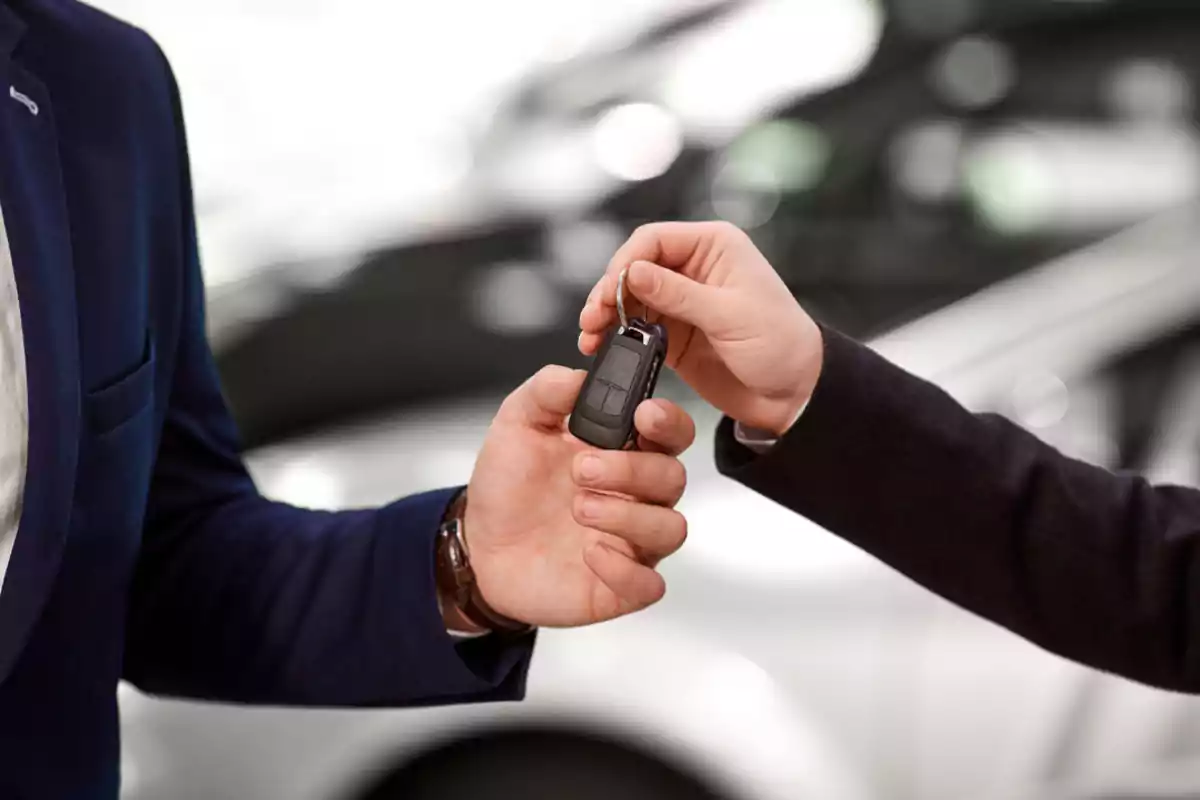 Two people handing over car keys at a dealership Two people handing over car keys at a dealership