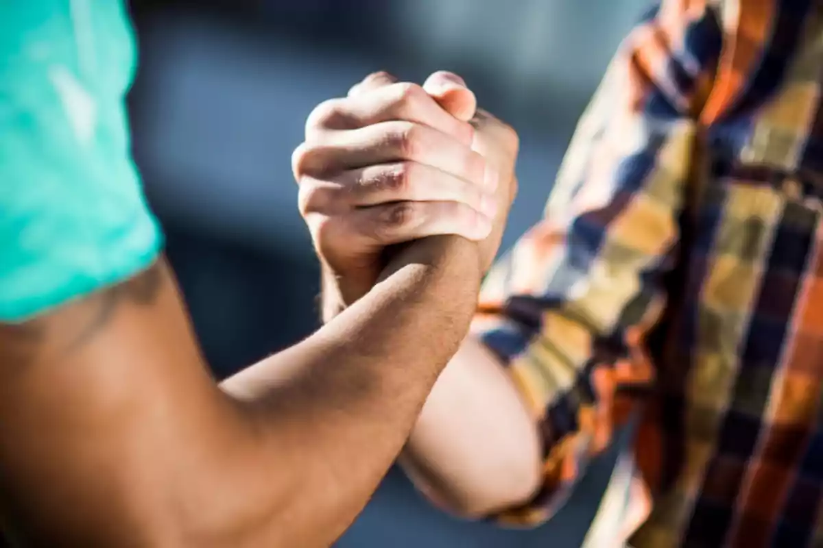 Two people shaking hands as a sign of agreement or friendship Two people shaking hands as a sign of agreement or friendship