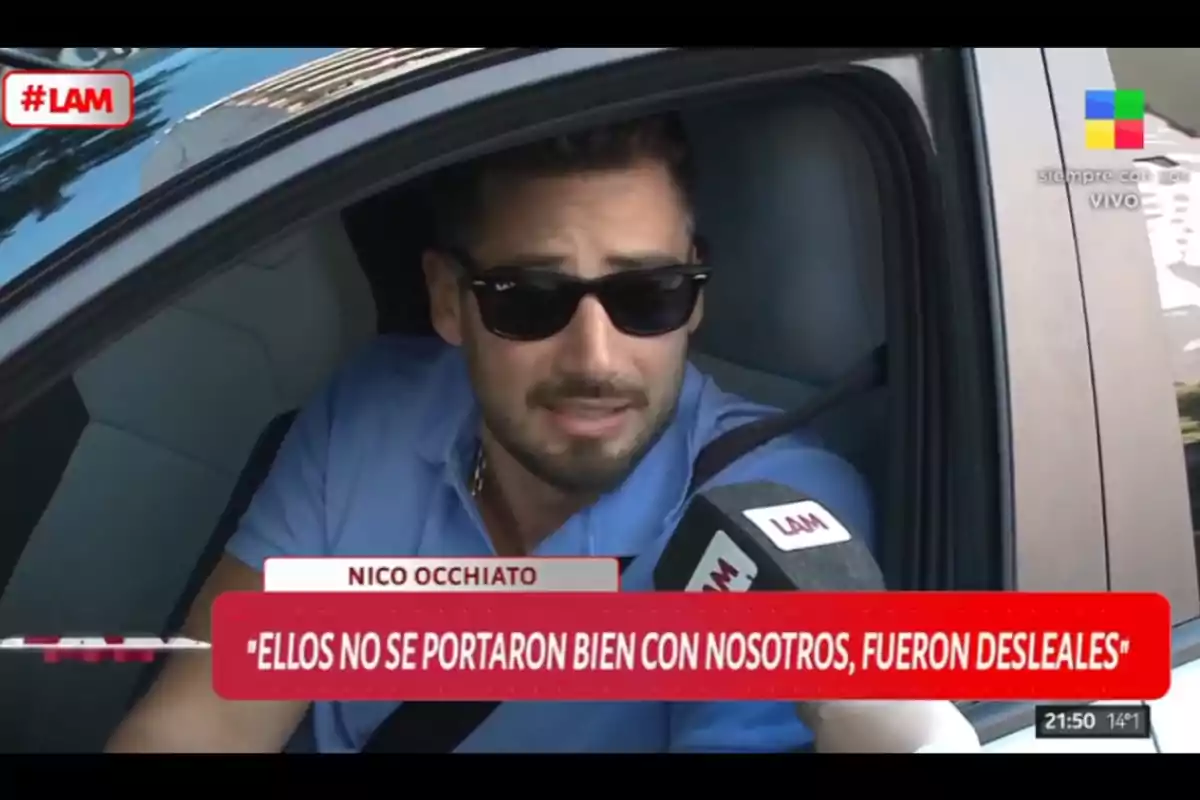 Hombre con gafas de sol hablando desde el interior de un auto mientras sostiene un micrófono de un programa de televisión llamado LAM, con un cartel que muestra una cita sobre deslealtad. Hombre con gafas de sol hablando desde el interior de un auto mientras sostiene un micrófono de un programa de televisión llamado LAM, con un cartel que muestra una cita sobre deslealtad.