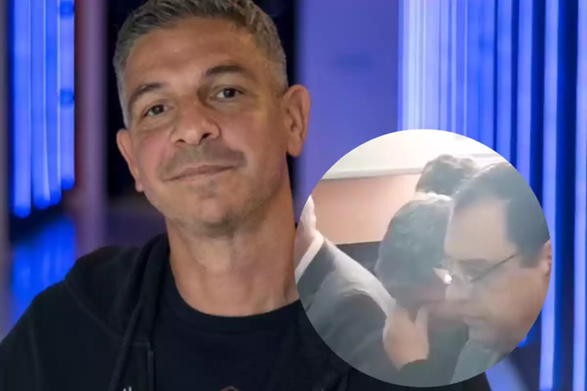 Short-haired, gray-haired man smiles slightly in front of a blue background with a circular overlay image showing two men in an indoor setting.