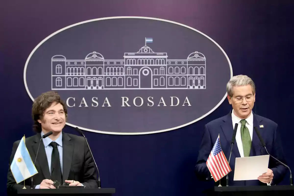 Two men in suits at a podium with Argentine and United States flags in front of a sign that says Casa Rosada Two men in suits at a podium with Argentine and United States flags in front of a sign that says Casa Rosada