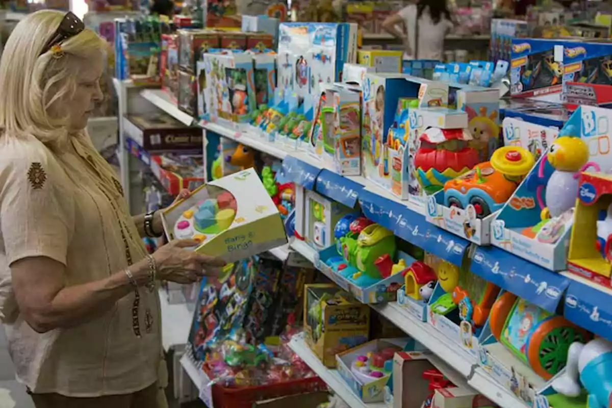 Woman looking at a box of toys in a store with shelves full of colorful toys Woman looking at a box of toys in a store with shelves full of colorful toys