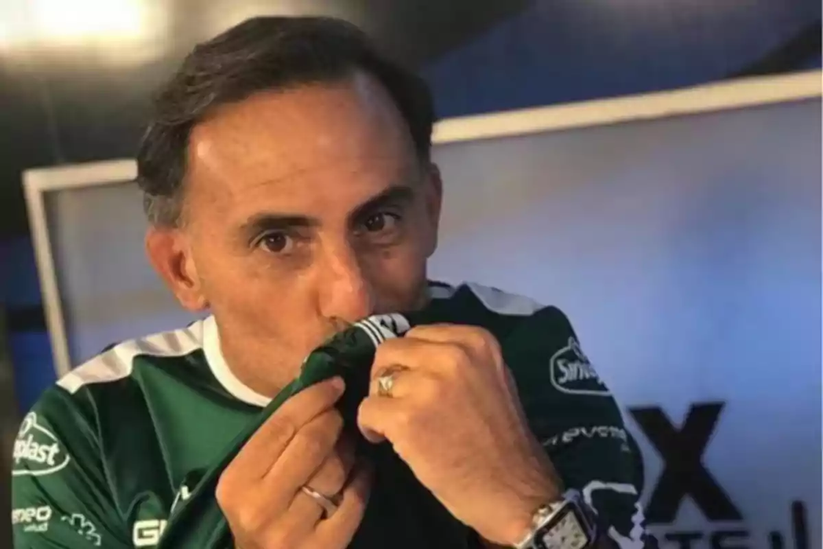 Hombre besando el escudo de una camiseta de fútbol verde en un estudio de televisión Hombre besando el escudo de una camiseta de fútbol verde en un estudio de televisión