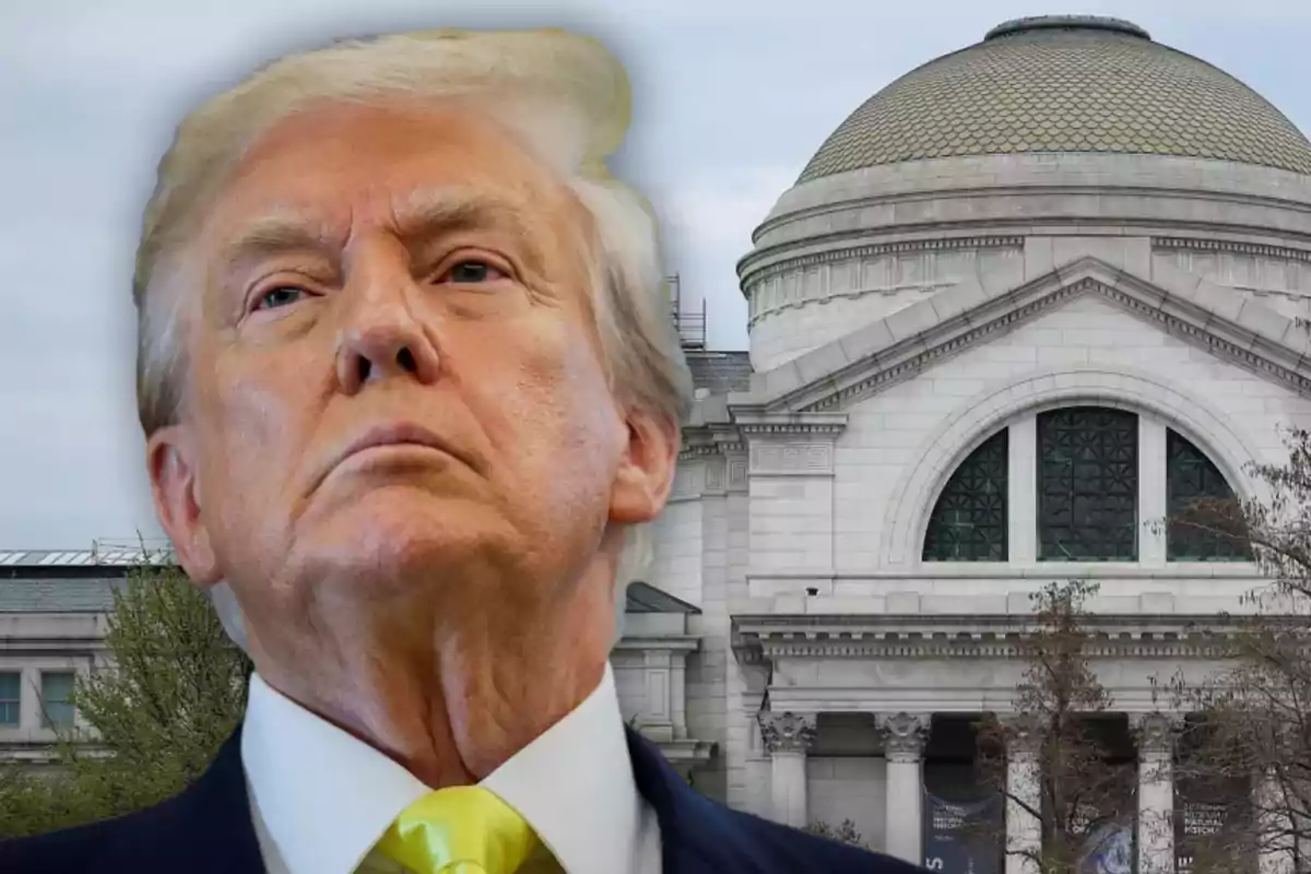 Blond-haired man with a serious expression in front of a large-domed building with a white stone facade