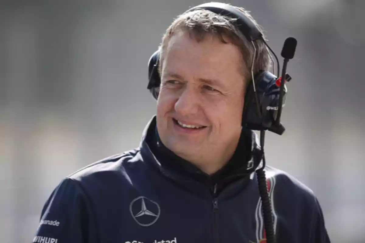 Man with headphones and microphone wearing a blue racing team jacket Man with headphones and microphone wearing a blue racing team jacket