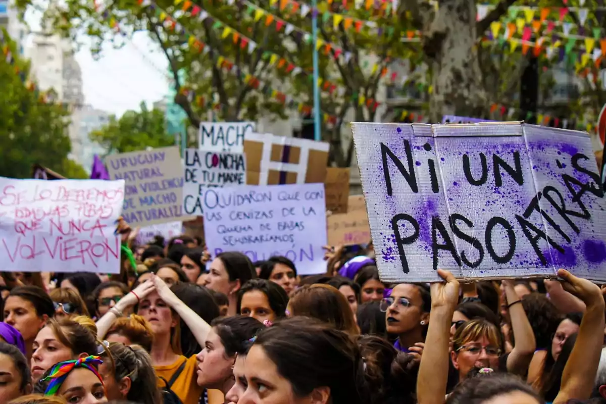 Women marching in a feminist demonstration holding signs with messages of protest and demands