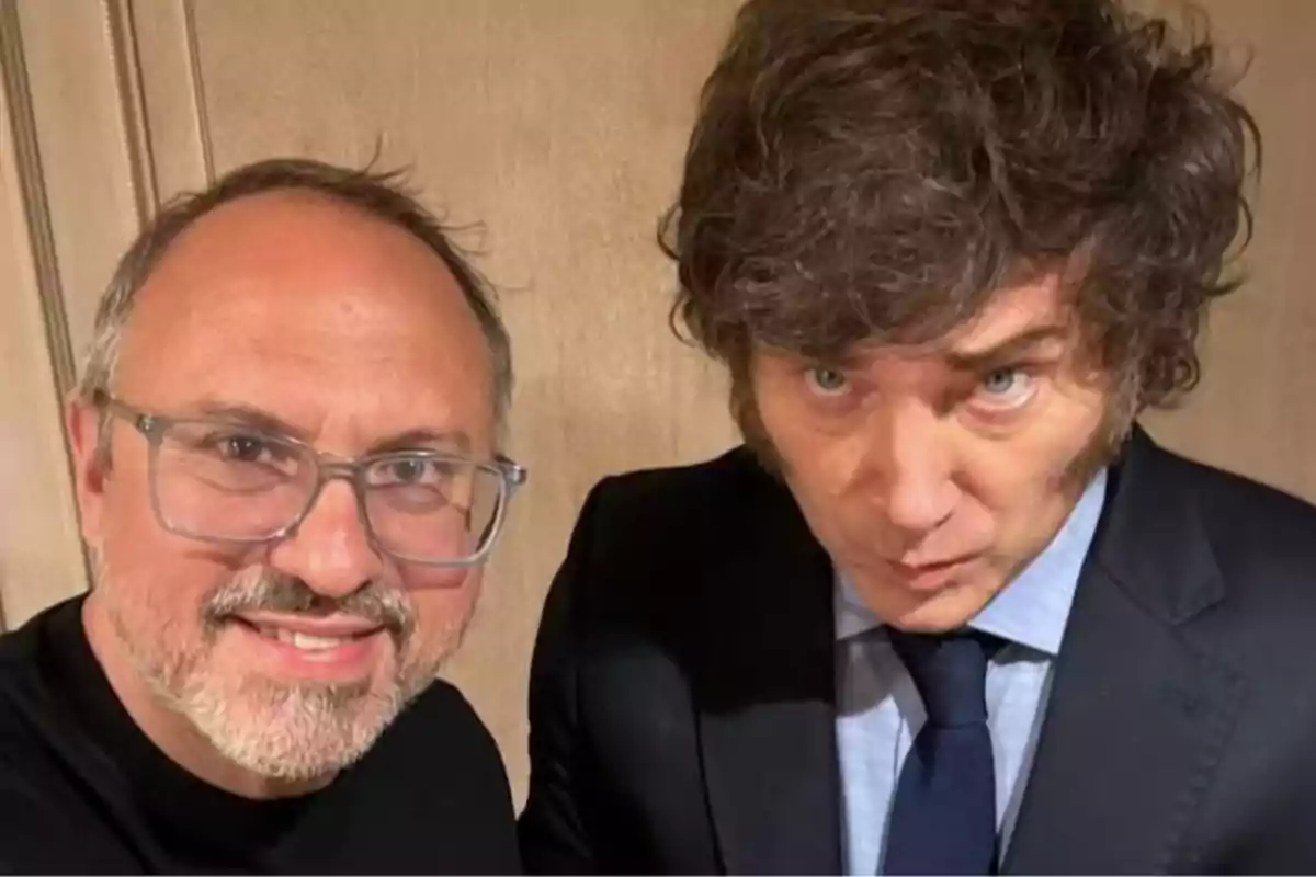 Dos hombres posan juntos para una selfie uno de ellos lleva gafas y barba mientras que el otro viste traje y corbata Dos hombres posan juntos para una selfie uno de ellos lleva gafas y barba mientras que el otro viste traje y corbata
