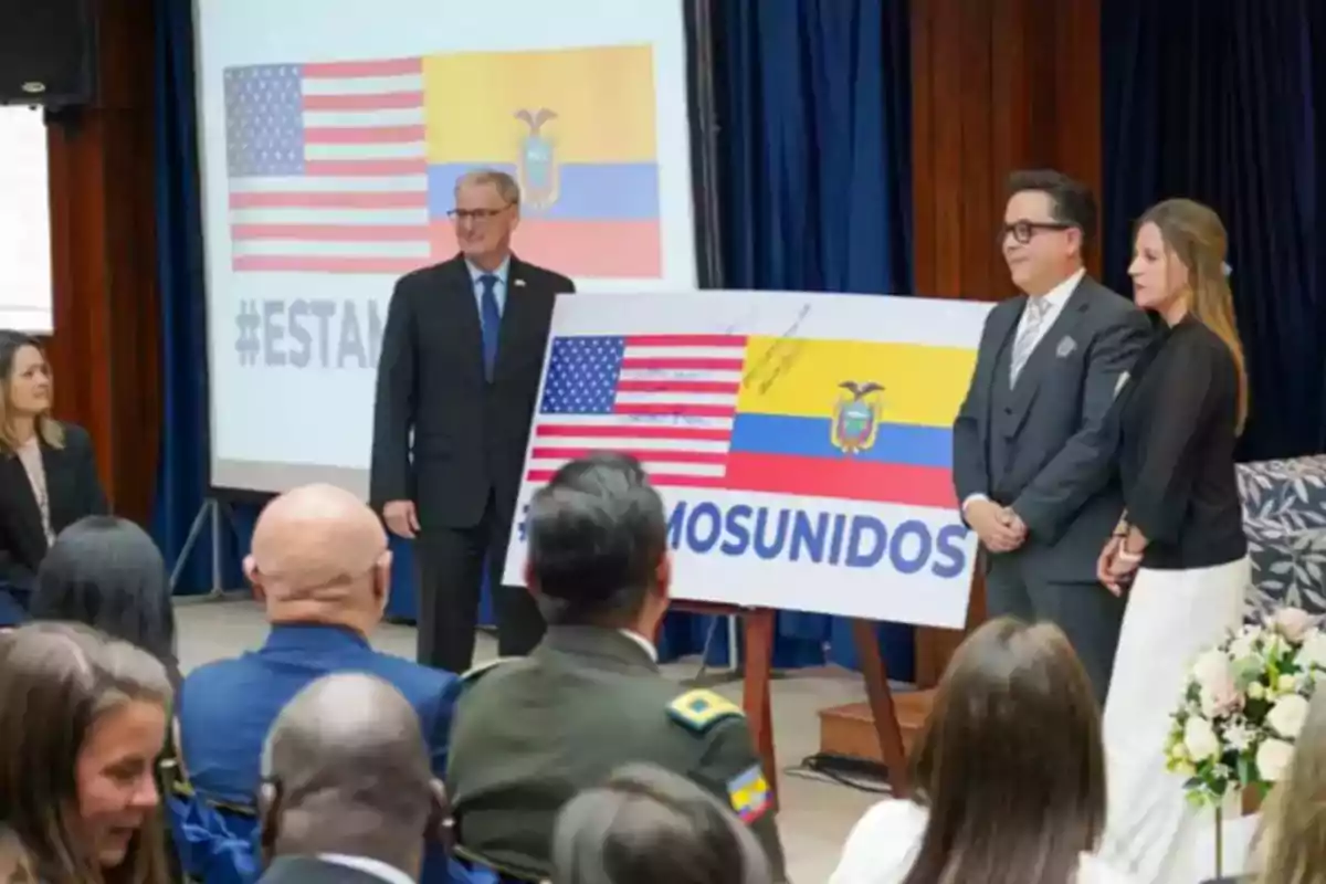 Varias personas en un evento formal sostienen un cartel con las banderas de Estados Unidos y Ecuador y la palabra Varias personas en un evento formal sostienen un cartel con las banderas de Estados Unidos y Ecuador y la palabra