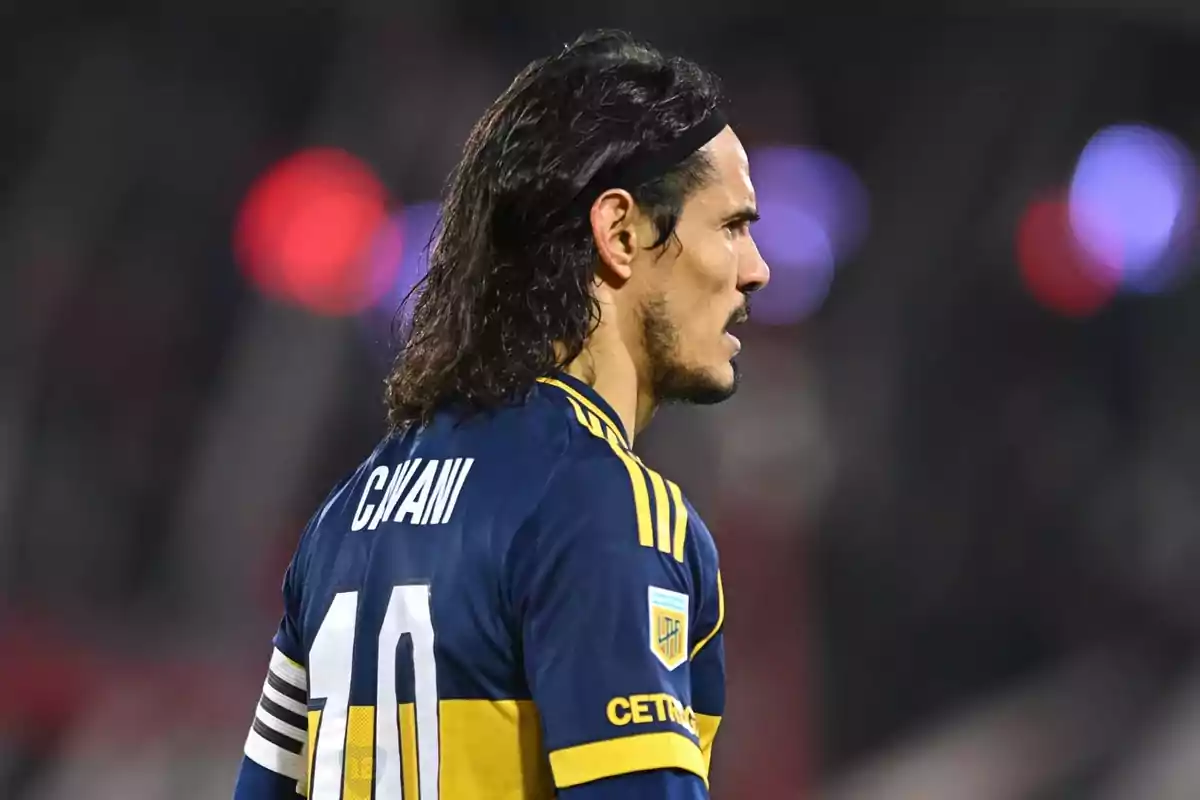 Futbolista con cabello largo y cinta negra usando el uniforme azul y amarillo de Boca Juniors con el número 10 y el nombre Cavani en la espalda Futbolista con cabello largo y cinta negra usando el uniforme azul y amarillo de Boca Juniors con el número 10 y el nombre Cavani en la espalda