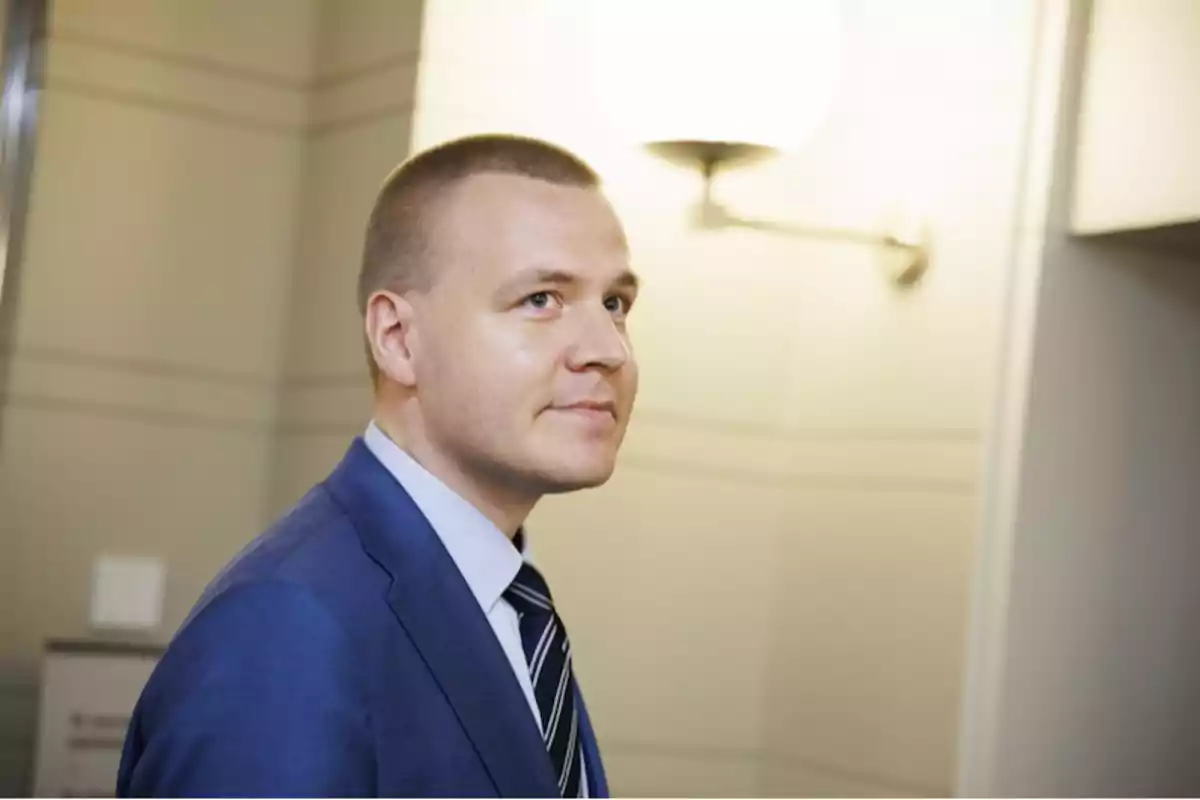 Young man in a blue suit and striped tie in a well-lit indoor setting Young man in a blue suit and striped tie in a well-lit indoor setting