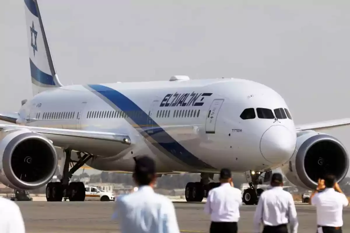 Avión de la aerolínea El Al en pista con varias personas observando en primer plano