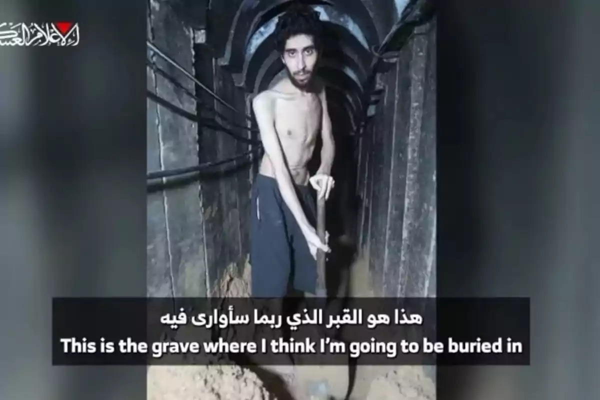A thin, jerseyless man is digging with a shovel inside a dark, narrow tunnel, with cables on the sides and a message in Arabic and English at the bottom of the image. A thin, jerseyless man is digging with a shovel inside a dark, narrow tunnel, with cables on the sides and a message in Arabic and English at the bottom of the image.