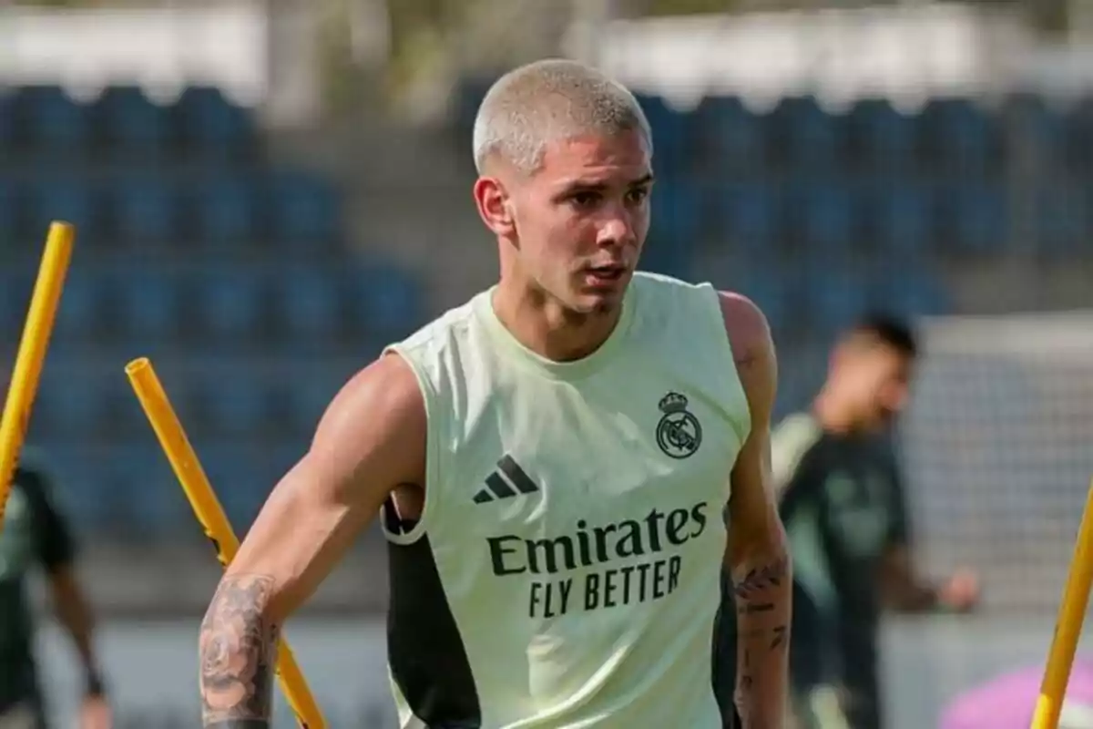 Soccer player training in a sleeveless Real Madrid jersey on a training field with yellow cones