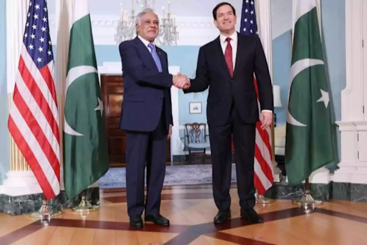 Dos hombres de traje se dan la mano en una sala elegante con banderas de Estados Unidos y Pakistán a su alrededor Dos hombres de traje se dan la mano en una sala elegante con banderas de Estados Unidos y Pakistán a su alrededor