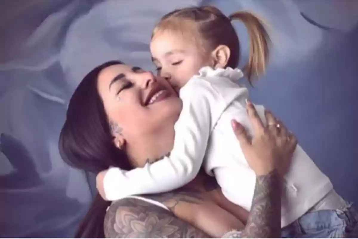 Mujer sonriente abrazando y recibiendo un beso de una niña pequeña en un ambiente cálido y amoroso Mujer sonriente abrazando y recibiendo un beso de una niña pequeña en un ambiente cálido y amoroso