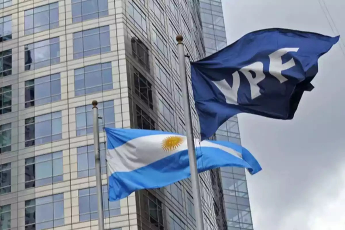 YPF and Argentine flags waving in front of a modern office building