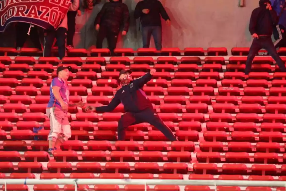 Aficionados en una tribuna vacía durante un altercado en un estadio de fútbol Aficionados en una tribuna vacía durante un altercado en un estadio de fútbol