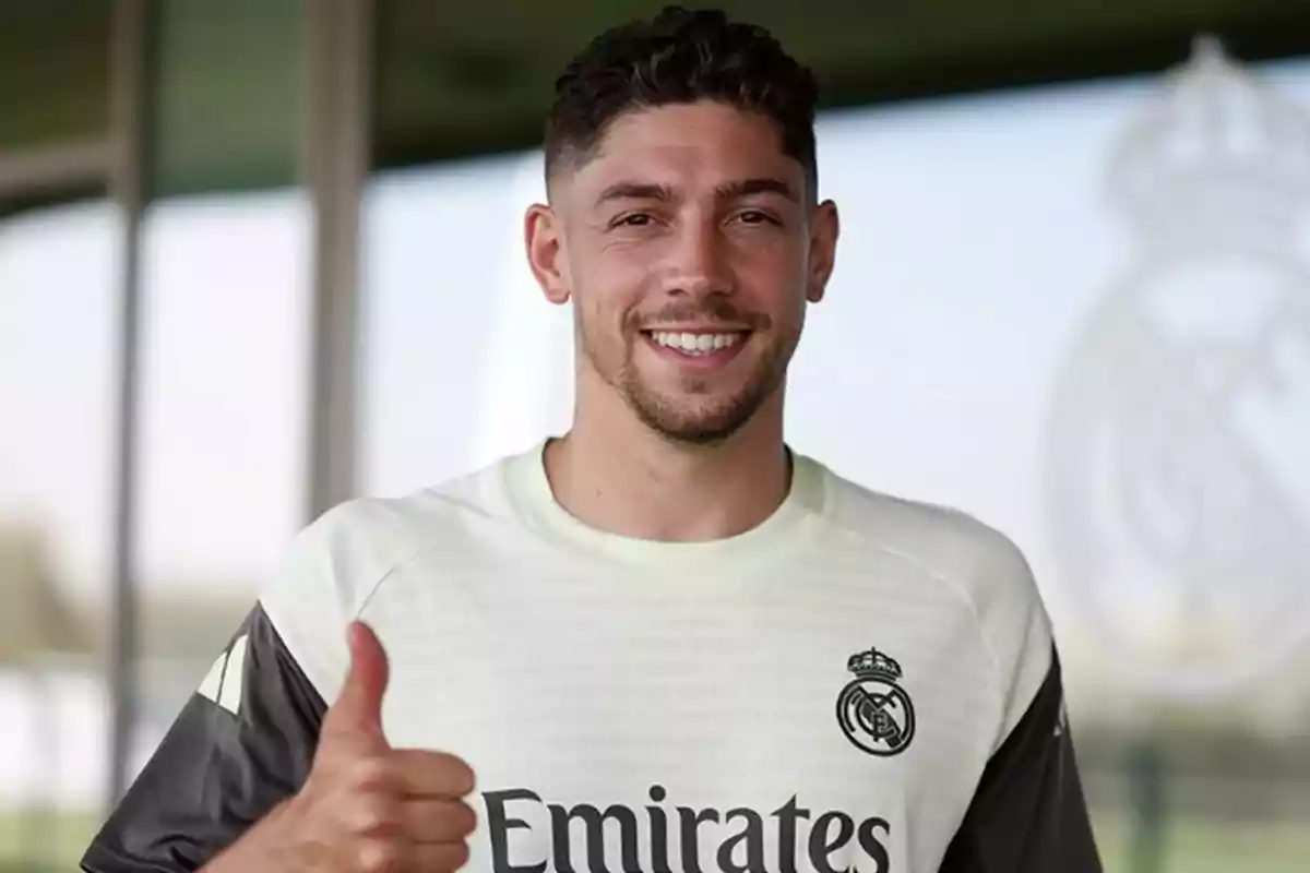 Soccer player wearing a Real Madrid training jersey smiling and giving a thumbs up in approval Soccer player wearing a Real Madrid training jersey smiling and giving a thumbs up in approval