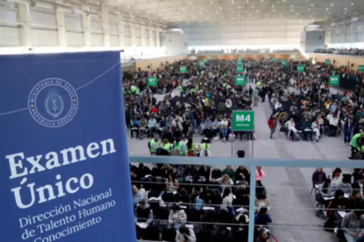 Gran cantidad de personas sentadas en un salón amplio y bien iluminado, participando en un examen organizado por el Ministerio de Salud, con carteles verdes que indican diferentes áreas y un cartel azul al frente que dice Examen Único. Gran cantidad de personas sentadas en un salón amplio y bien iluminado, participando en un examen organizado por el Ministerio de Salud, con carteles verdes que indican diferentes áreas y un cartel azul al frente que dice Examen Único.
