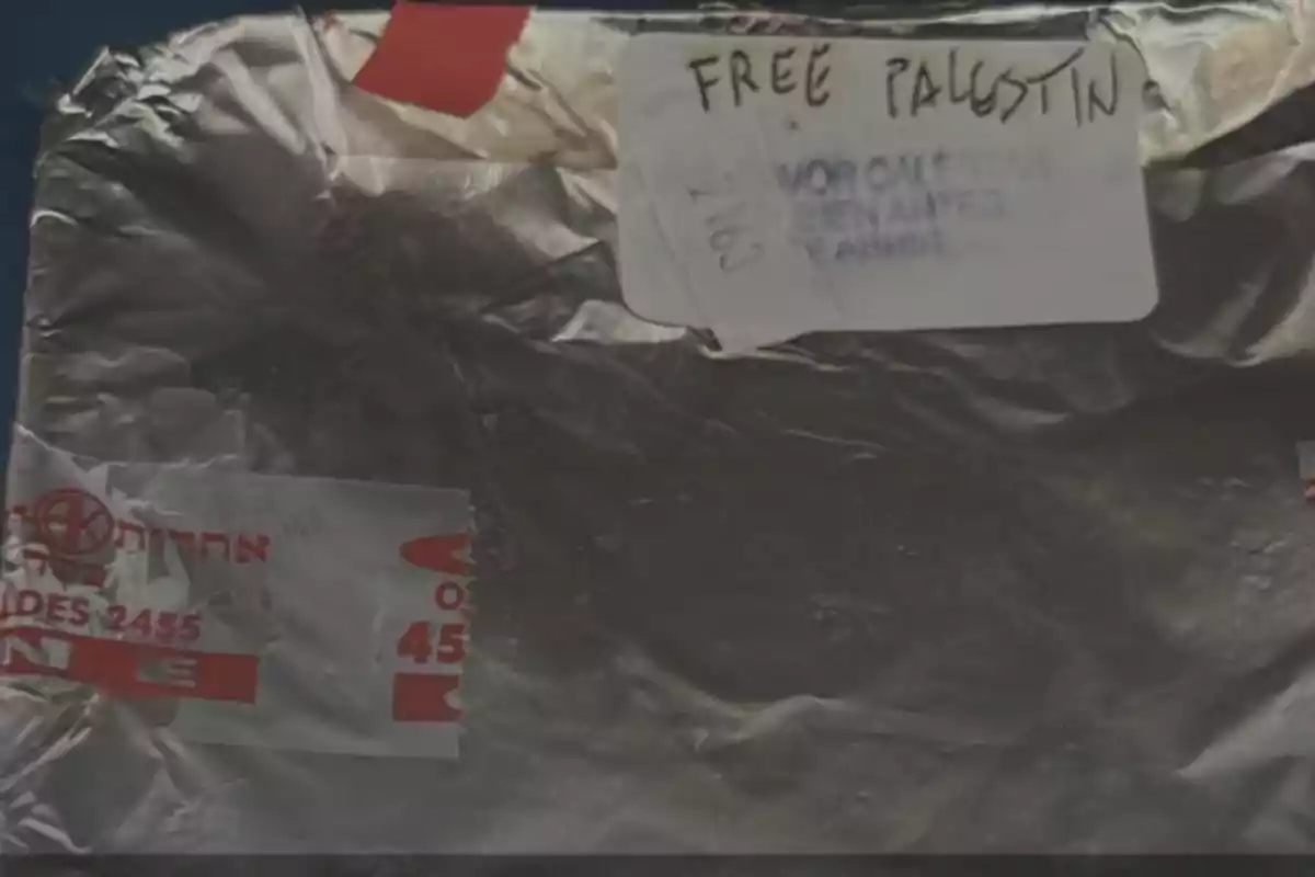Paquete envuelto en papel aluminio con etiquetas y la frase Free Palestine escrita a mano en una de ellas
