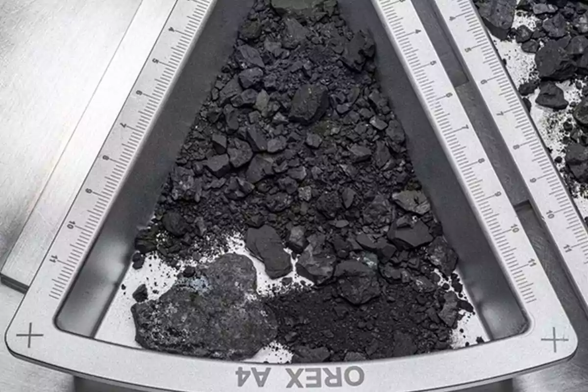 Fragments of black rock on a triangular metal tray with millimeter-marked edges Fragments of black rock on a triangular metal tray with millimeter-marked edges