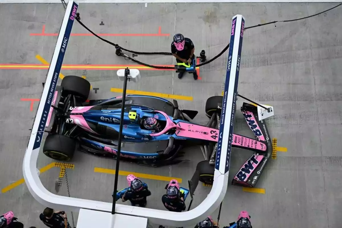 Un auto de Fórmula 1 del equipo Alpine en los boxes visto desde arriba mientras el equipo realiza una parada técnica Un auto de Fórmula 1 del equipo Alpine en los boxes visto desde arriba mientras el equipo realiza una parada técnica