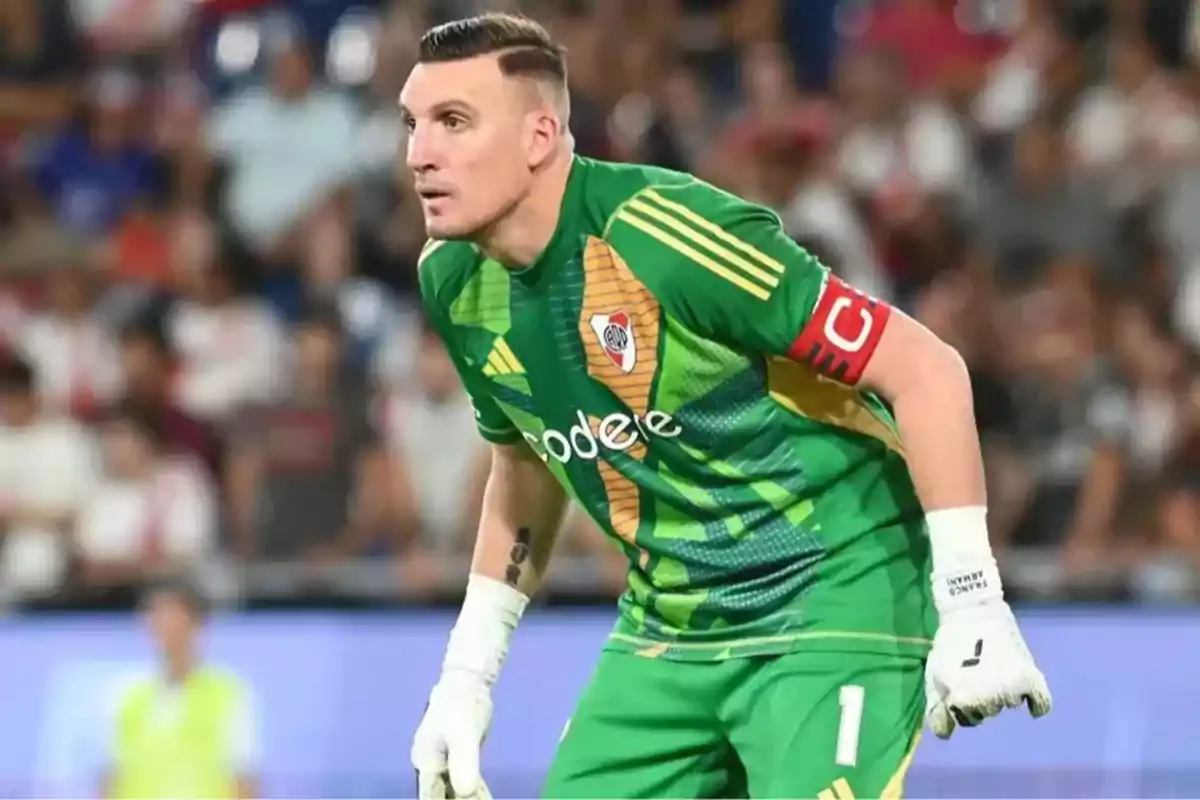 Portero de fútbol con uniforme verde y brazalete de capitán en un estadio durante un partido Portero de fútbol con uniforme verde y brazalete de capitán en un estadio durante un partido
