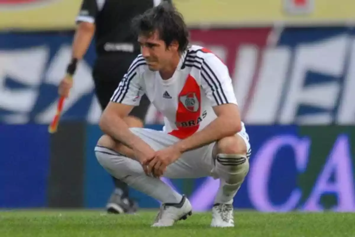 River Plate player crouched on the field with a sad expression River Plate player crouched on the field with a sad expression