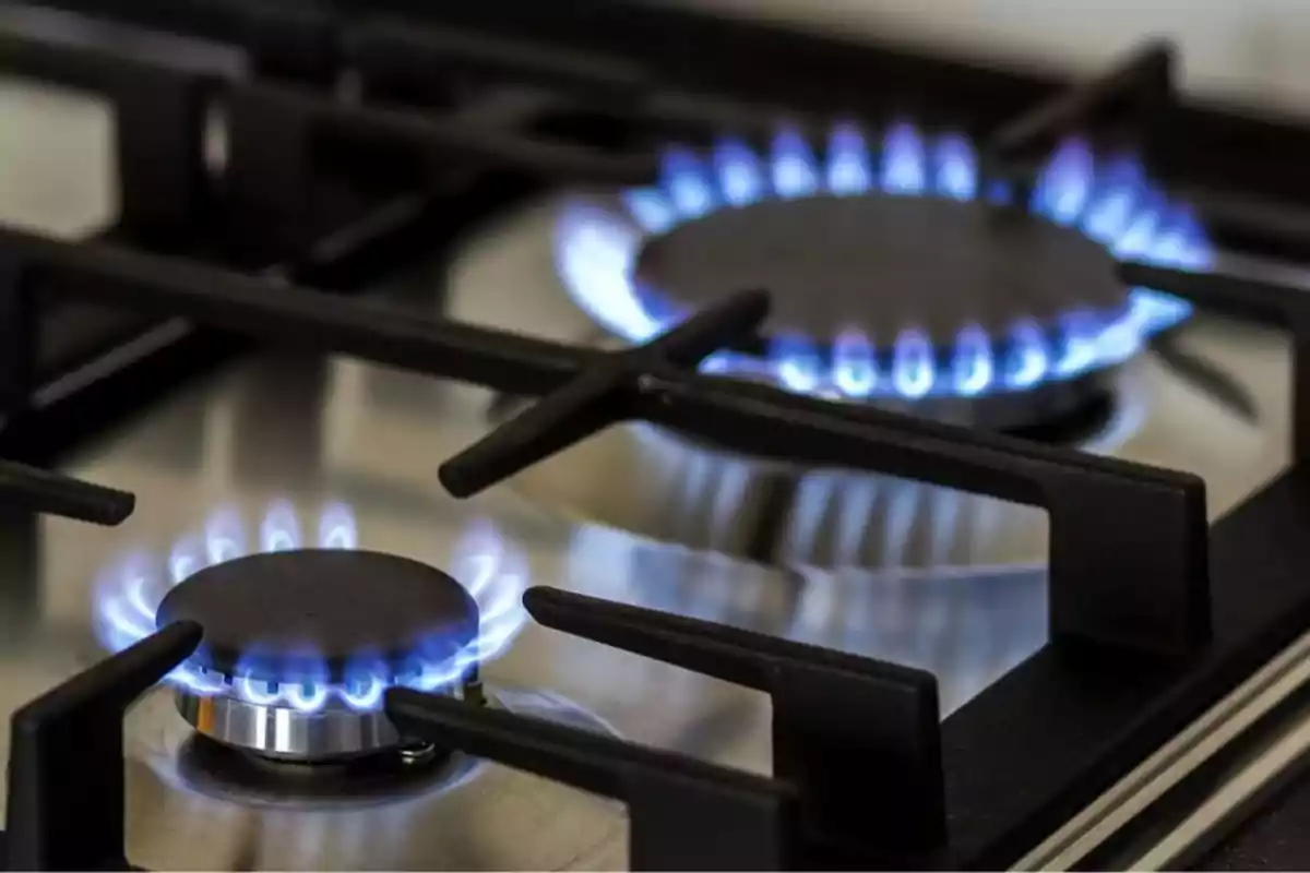 Gas stove on with two burners showing blue flames Gas stove on with two burners showing blue flames
