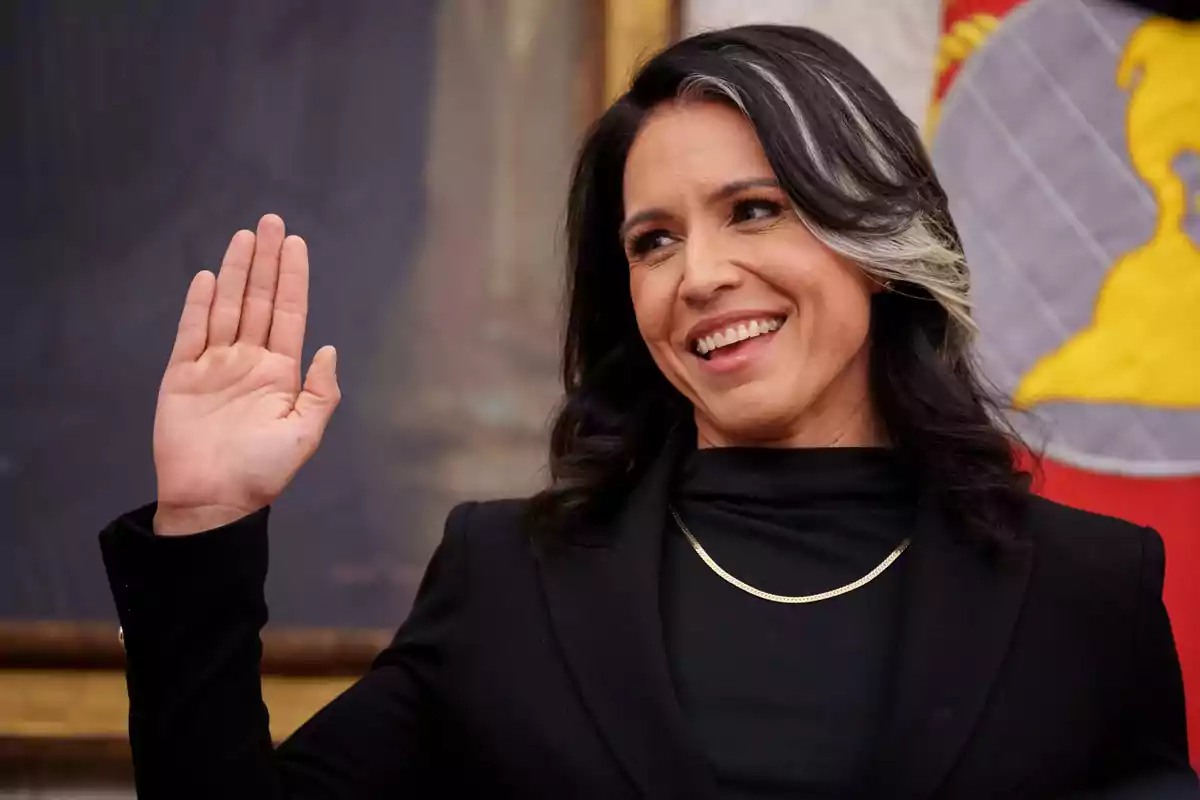 Mujer de cabello oscuro con una mecha blanca sonriendo y levantando la mano derecha en señal de juramento Mujer de cabello oscuro con una mecha blanca sonriendo y levantando la mano derecha en señal de juramento