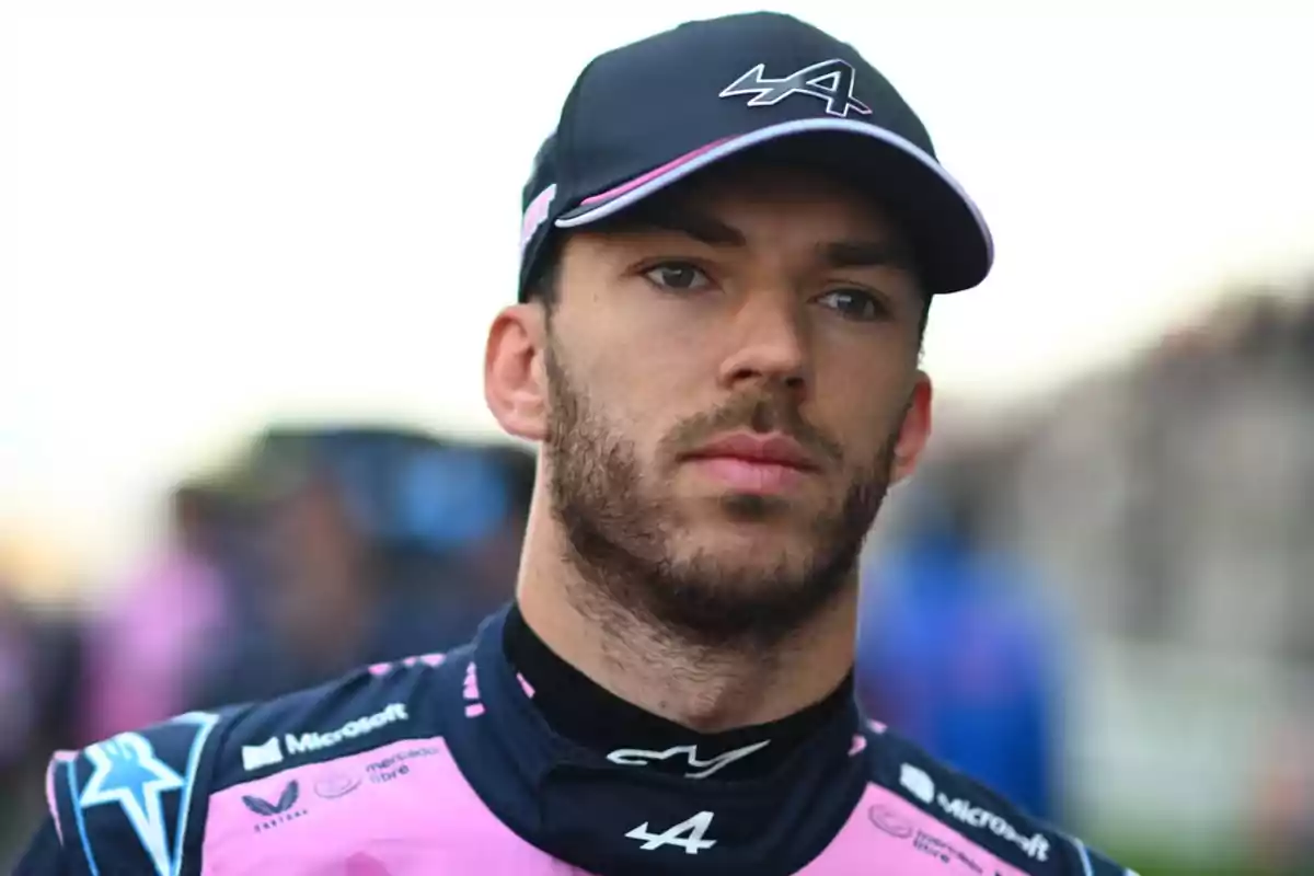 Motorsport driver wearing a blue and pink cap and uniform from a racing team Motorsport driver wearing a blue and pink cap and uniform from a racing team