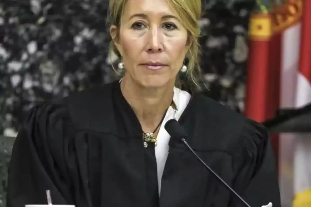 Jueza sentada en su estrado con toga negra y micrófono frente a ella
