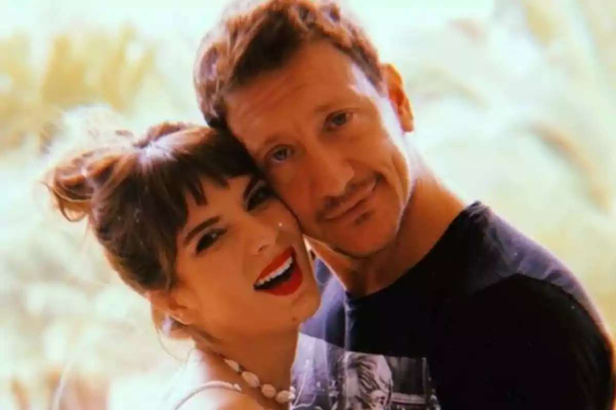 Pareja abrazada sonriendo frente a la cámara con fondo desenfocado Pareja abrazada sonriendo frente a la cámara con fondo desenfocado