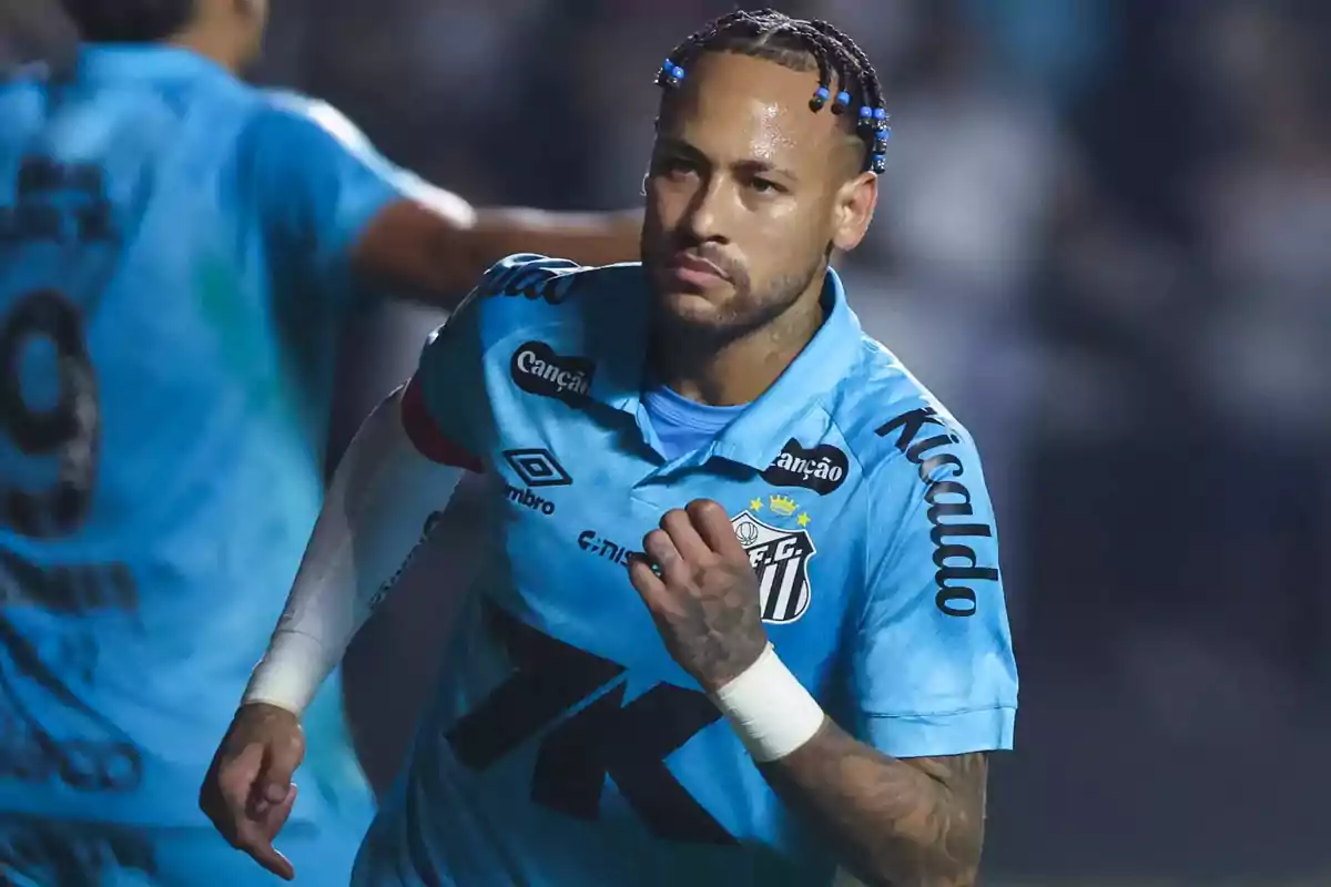 Soccer player in a light blue Santos uniform celebrating a goal during a match